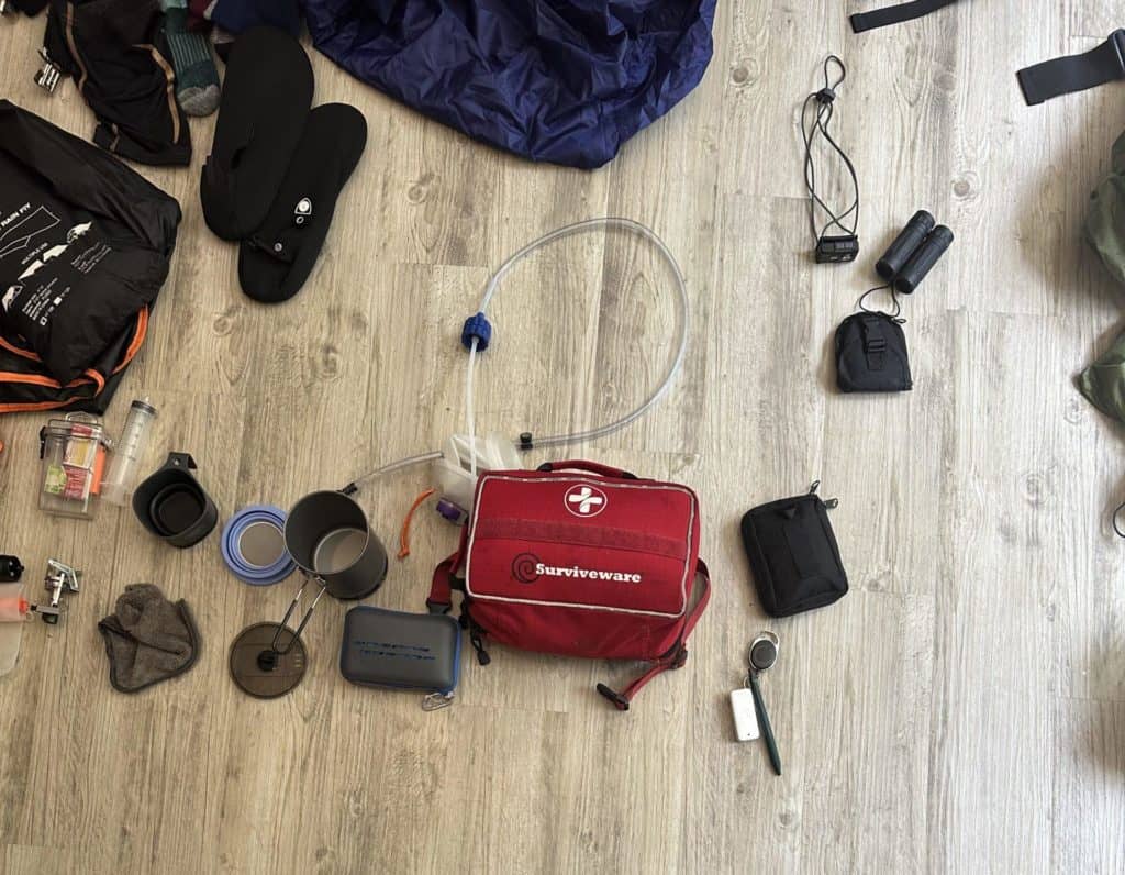Backpacking gear scattered on the floor. | Preparing for an Eremos Guided Hike